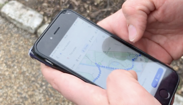 Hand holding smartphone with navigation app open